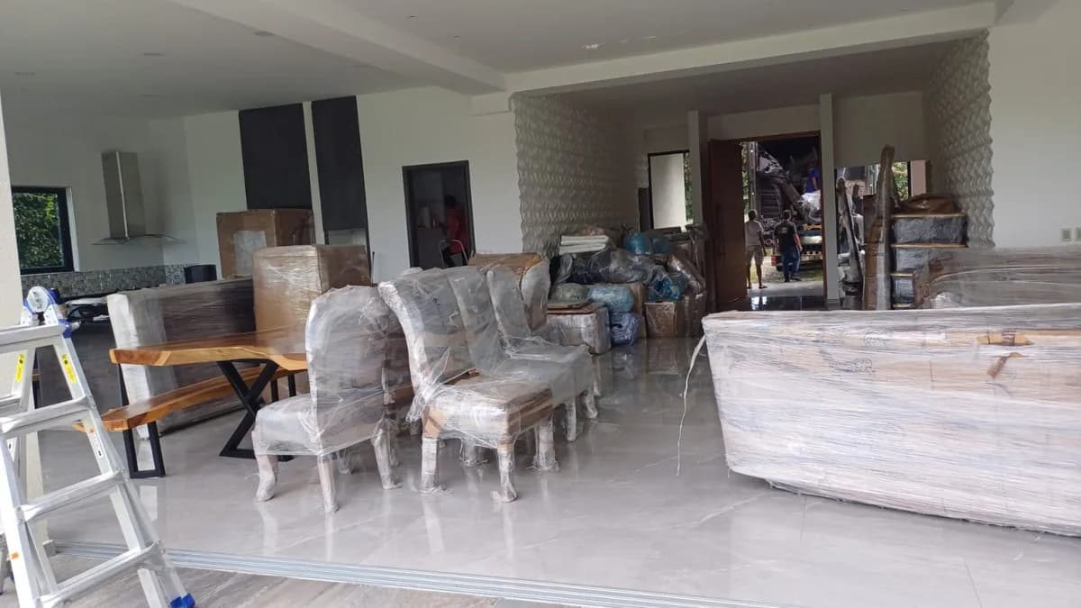 Muebles y sillas embalados listos para trasladar en un apartamento amplio de Bogotá
