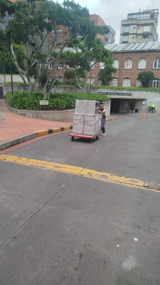 Operario de ALC Mudanzas trasladando cajas en un carro de carga