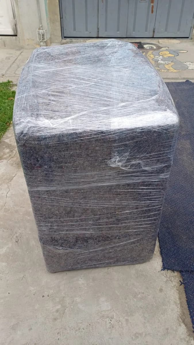 Mueble grande envuelto y protegido con manta y vinipel para el traslado