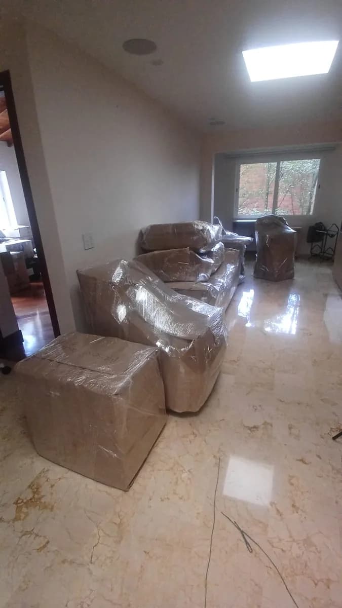 Sofá y muebles envueltos y protegidos en un apartamento antes del traslado